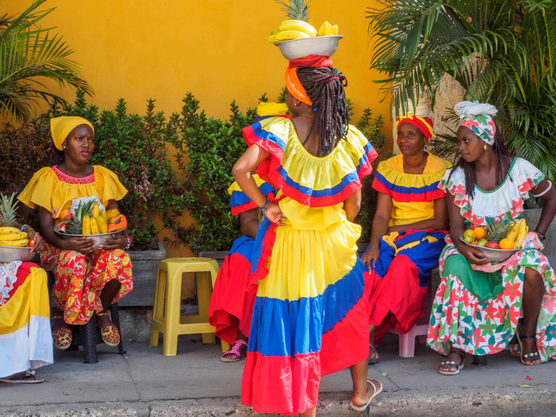 Colorfully dresssed women who pose for pictures with tourists for a fee