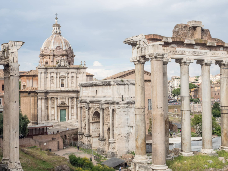 Ruins in the Forum of ancient Rome and a Baroque church
