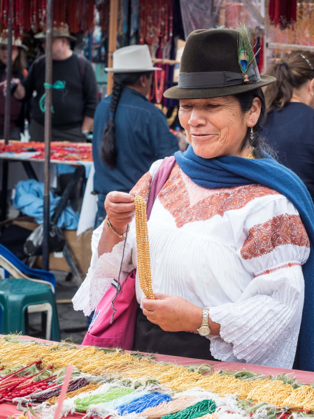 A woman looks at the gold beaded necklaces traditionally worn by Otavalo women.
