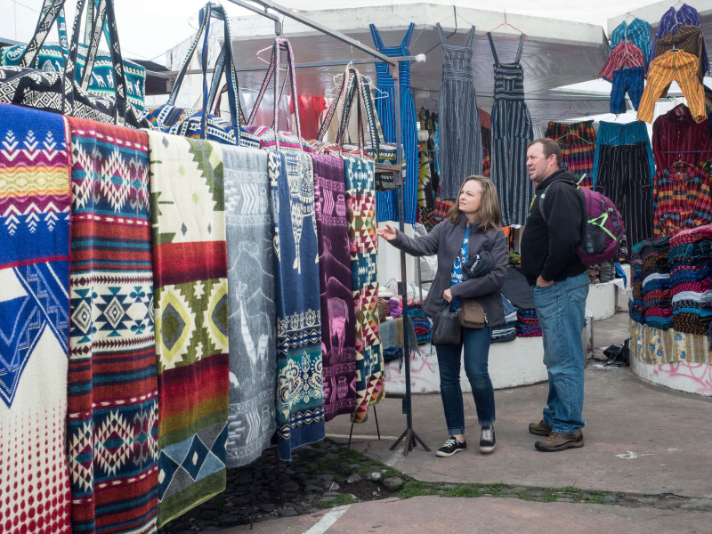 Visitors check out goods in the Otavalo market.  Most of the things for sale these days are mass produced rather than made by hand.