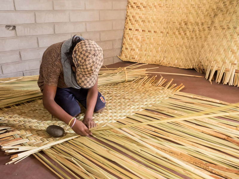 A boy in the village of San Rafael weaves a mat from totora reeds that grow on the shores of nearby San Pablo Lake
