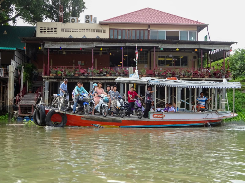 People on motorbikes crossing the river on a ferry boat