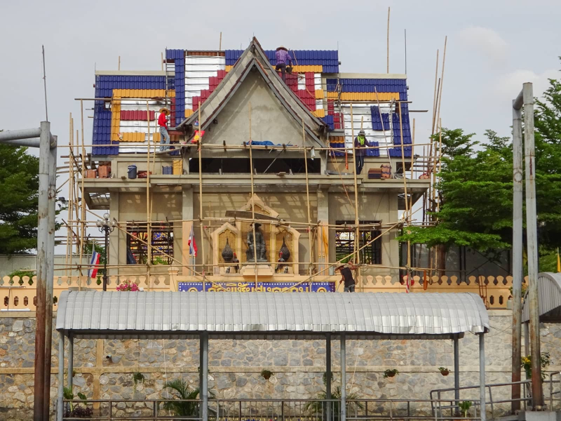 Multicolored roof tiles, which look from a distance like Legos, are installed on a temple building