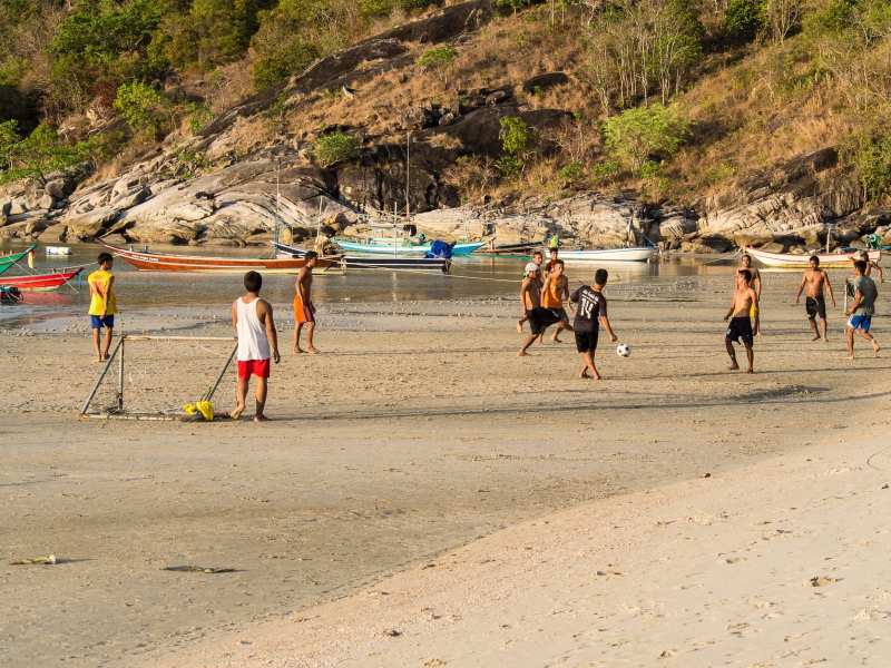 In early evening, young men who work along the beach play soccer on the sand
