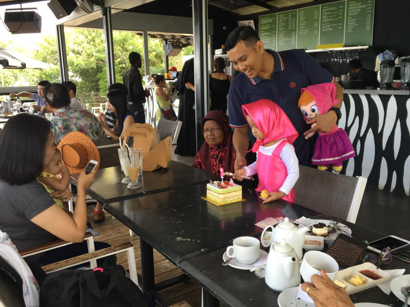 A family celebrates their daughter's 2nd birthday in a cafe on Penang Hill