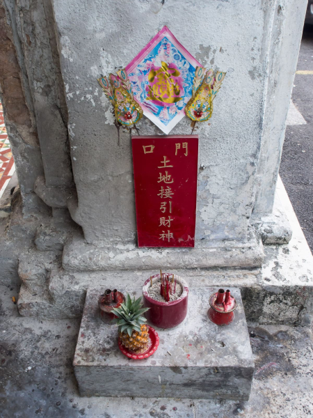 The lower of the two shrines in front of a Chinese shophouse.