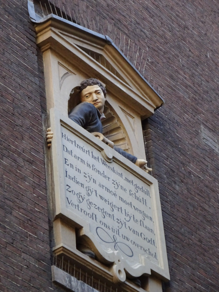 A plaque on the outside wall of an old orphanage (now the Amsterdam City Museum) asking passersby to donate to the orphanage