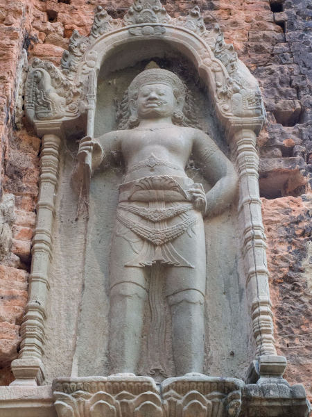 A gate guardian wearing an elaborately folded cloth around his legs.