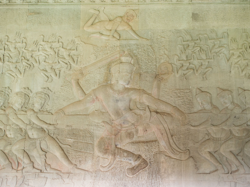 Vishnu in the middle helps with the churning (with demons on the left, gods on the right, and apsaras hovering above)