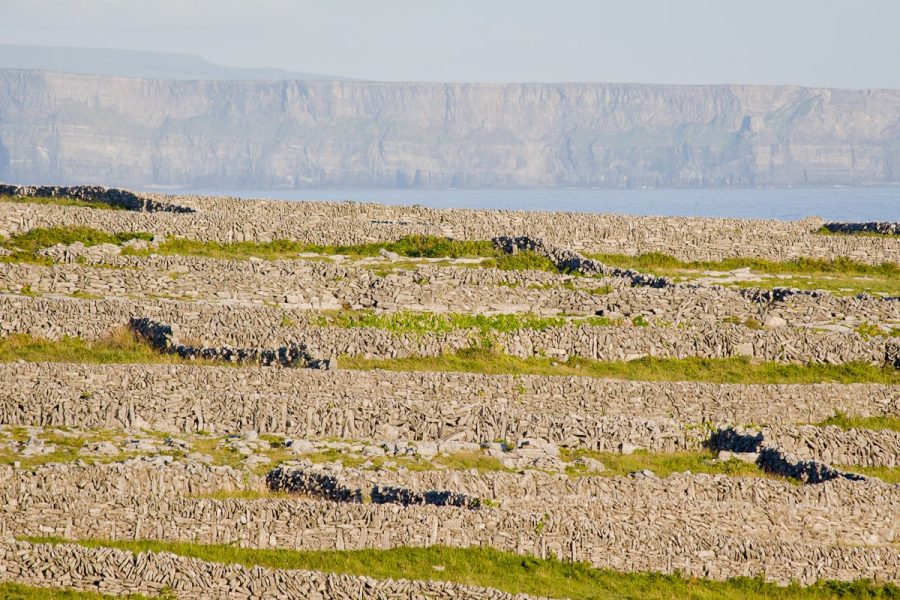 Looking past stone walls to the 600-foot Cliffs of Moher on the mainland