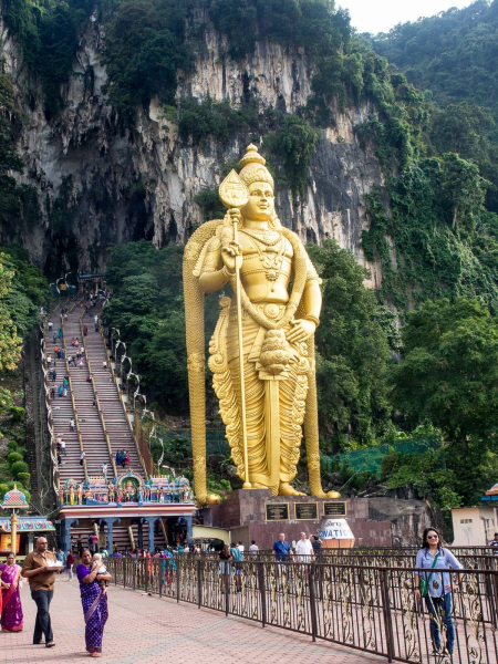 A 140-foot golden statue of the Tamil god Murugan by the entrance to the main temple cave