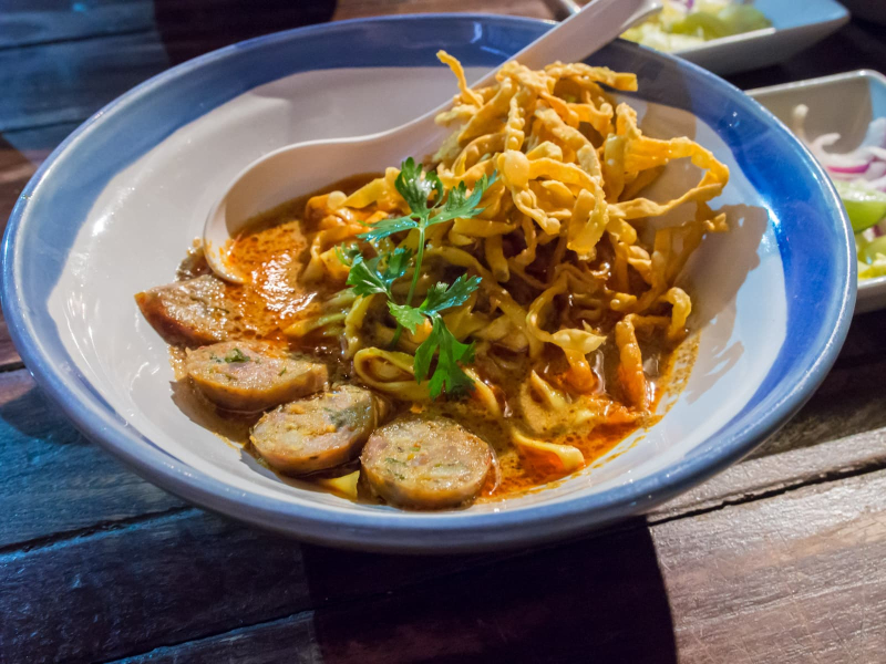 Kao soy is egg noodles in a rich curry broth served with slices of pork or sausage and fried wonton strips