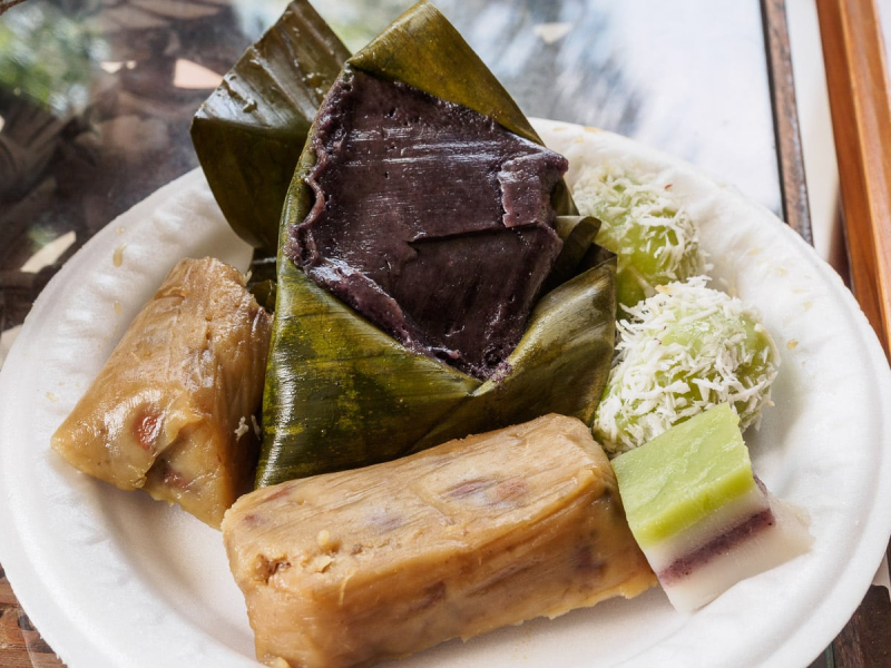 A plate of sweets given to everyone who attended (most are made of rice, bananas, beans, or fruit, steamed in banana leaves and sweetened with palm sugar syrup)