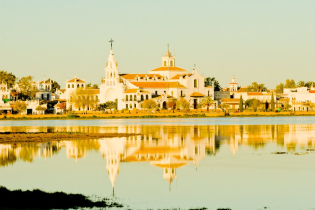 The church of Santa Maria del Rocio, a huge pilgrimage center, reflected in one of the marshes common in this area, next to Donana National Park
