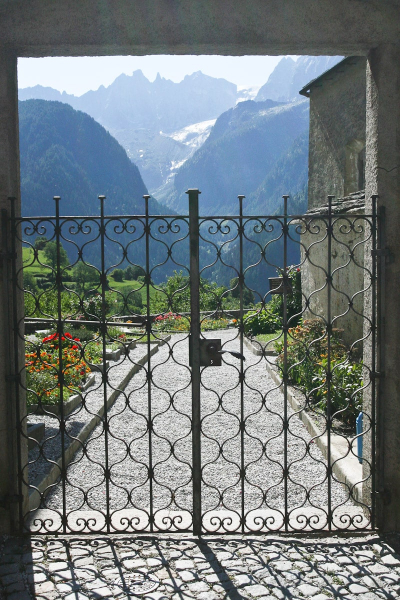 Looking through the churchyard gate to the mountains beyond Soglio