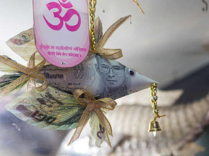A little good luck charm made of money hanging in a vendor's stall (all Thai bills have an image of the king)
