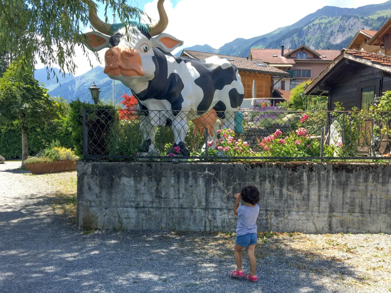 Francesca takes a picture of a cow sculpture in Brienz