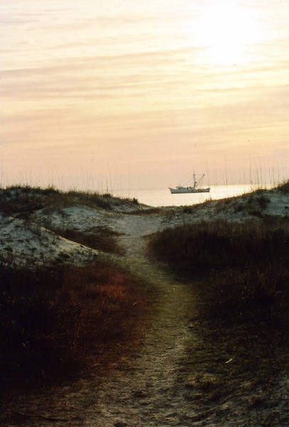 A fishing boat off the shore at dawn