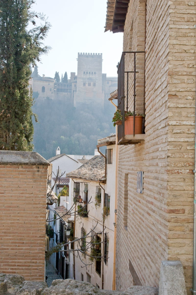 A typical alley in the lower Albaicin, with the Alhambra looming above.