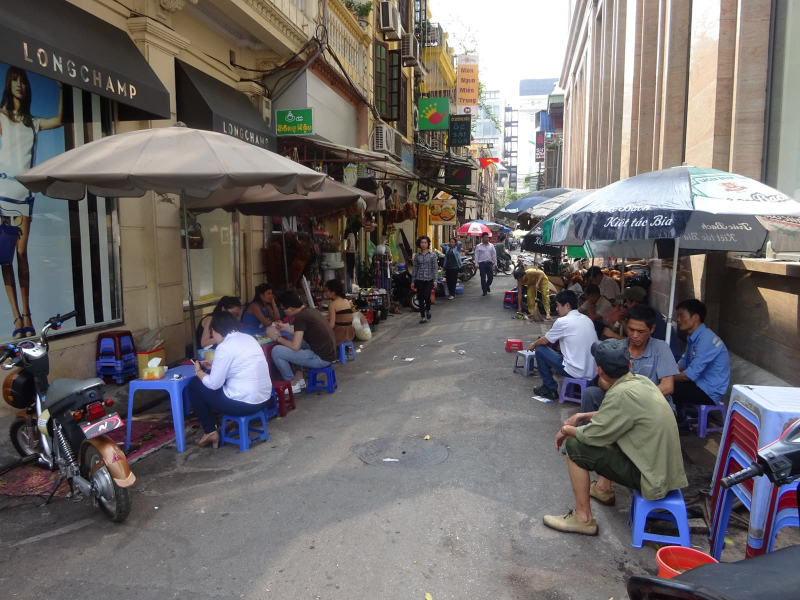 The streets are wider and the buildings are fancier in Hanoi's French Quarter, but eating on little plastic stools is still popular