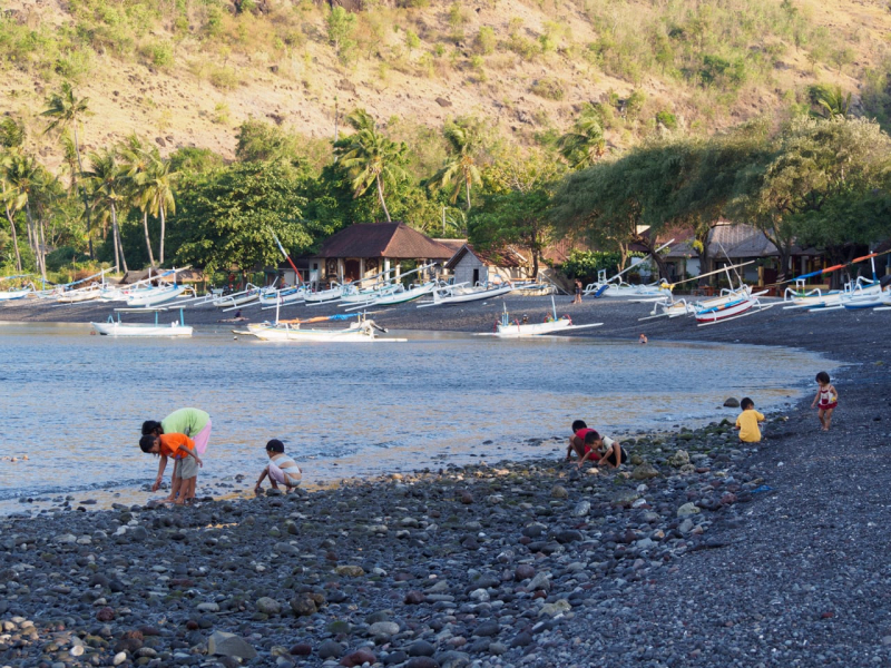 At low tide, local kids comb the beach in Jemeluk for small fish and eels, which the fishermen use as bait