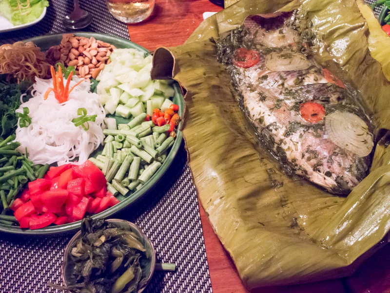 Part of a traditional Lao communal dinner we had at a restaurant: Red snapper steamed in banana leaves, and a plate of noodles and vegetables for making lettuce roll-ups