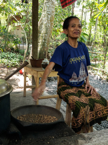A woman (who proudly announced that she's 75) roasting coffee beans collected from civets to make "kopi luwak"