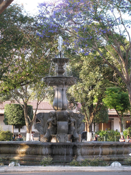 A fountain and purple jacaranda trees in the center of Nebaj
