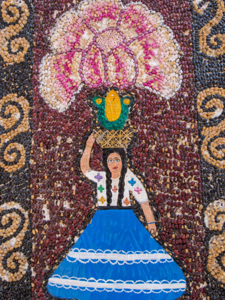 Detail of a bean mural shows a Oaxacan woman in festival clothes