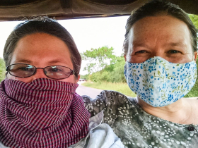 Keeping the dust out of our faces during tuk-tuk rides, with a traditional Cambodian scarf ("krama") and a modern face mask that cost 75 cents at the corner store