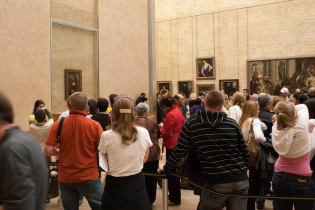 Tourists line up for a chance to see the Mona Lisa (on the left) in the Louvre Museum