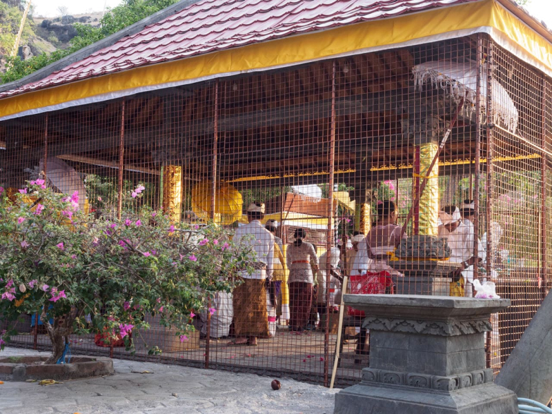 People coming to pray at the temple first perform a ritual in this outside area, caged to keep the monkeys out