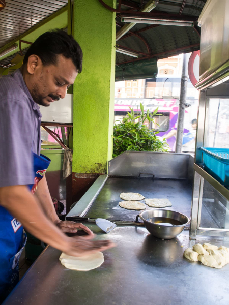 A man making the bread for one of Melissa's favorite dishes: roti canai