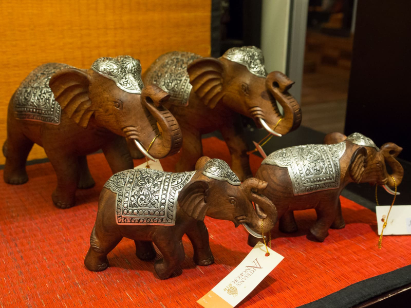 The finished metal designs decorate carved elephants