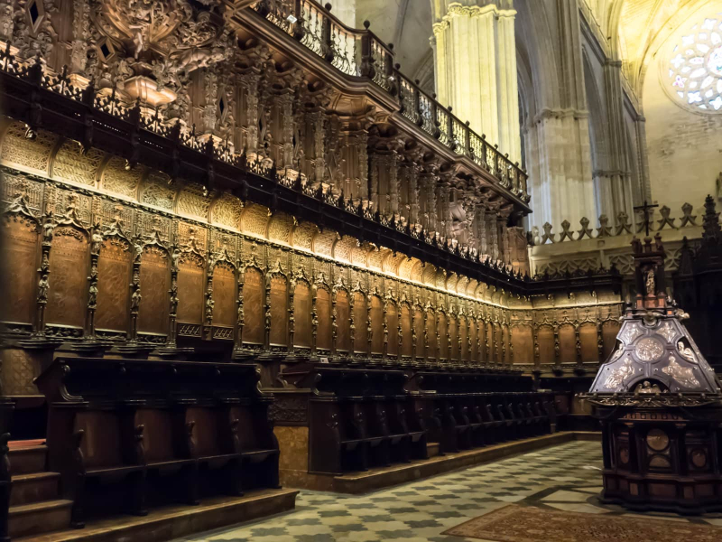 Carved wooden choir stalls and a four-sided lectern in the center of the cathedral