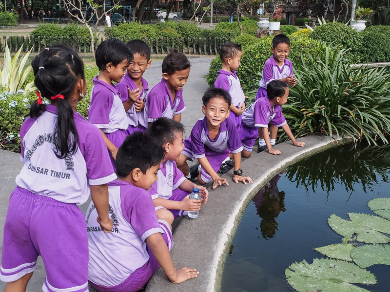 School kids at a fountain in the main square, where they had been having recess on the dusty grass