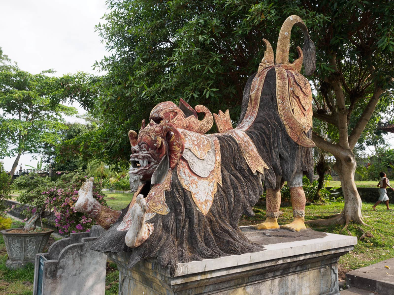 This statue of a barong playfully includes the feet of the two dancers wearing the barong costume