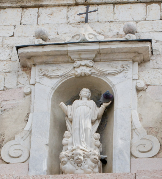 Angel, with pigeon, on a church in Spello