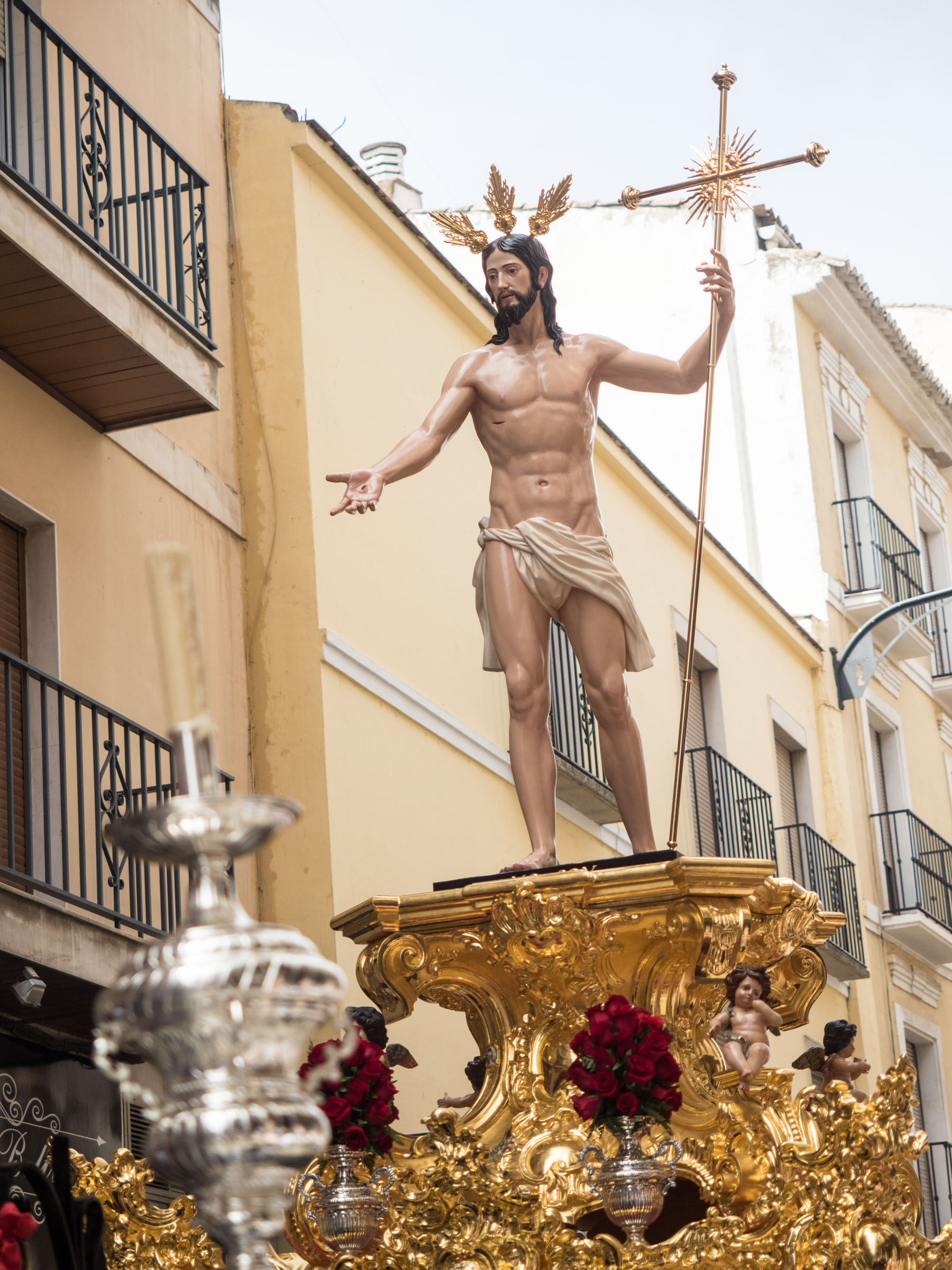 Figure of Christ in loincloth holding cross on gold float