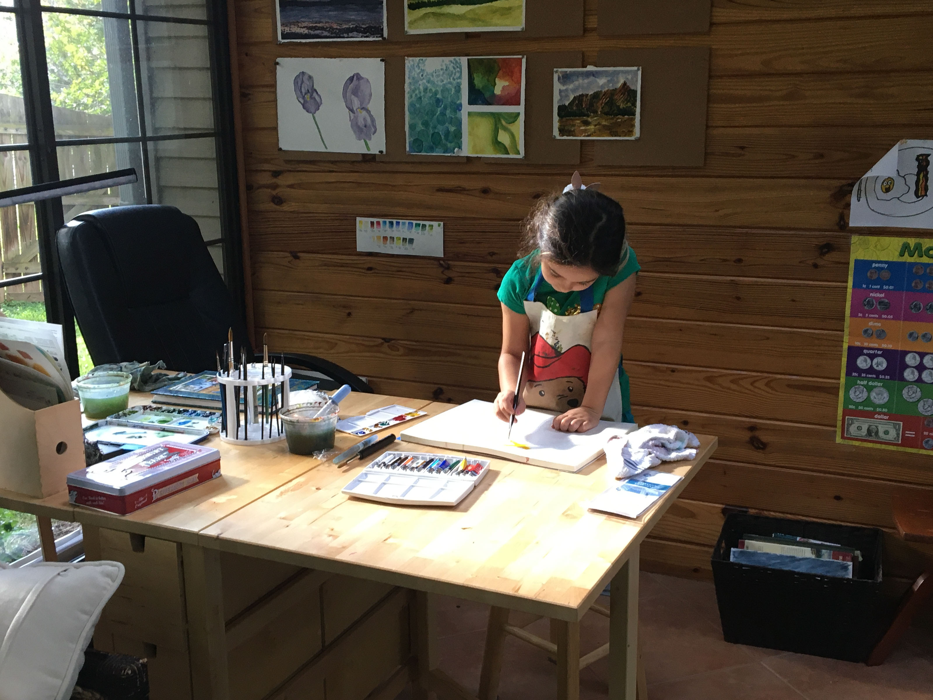 Francesca at a desk full of art supplies