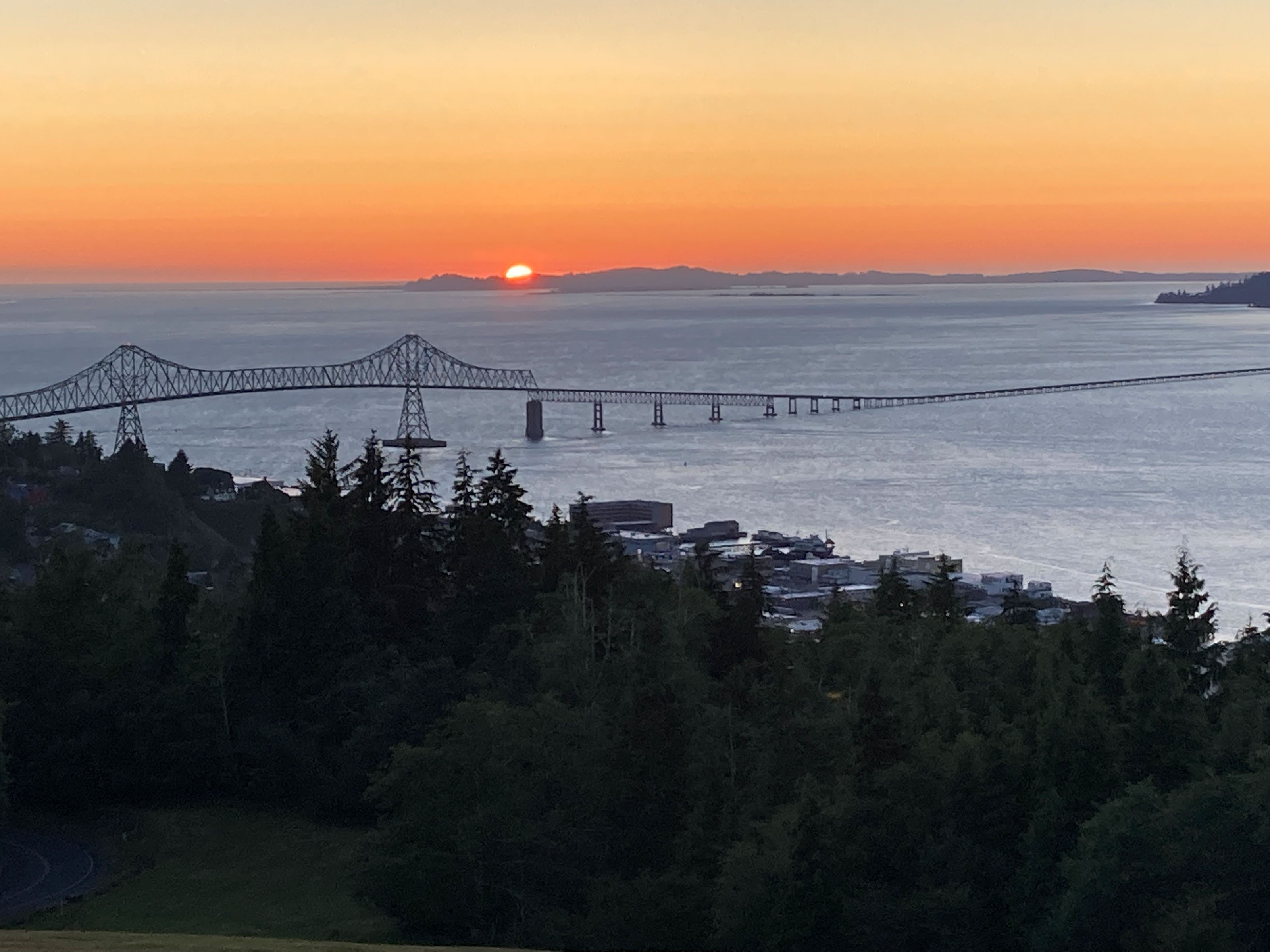 Sunset over water and long bridge