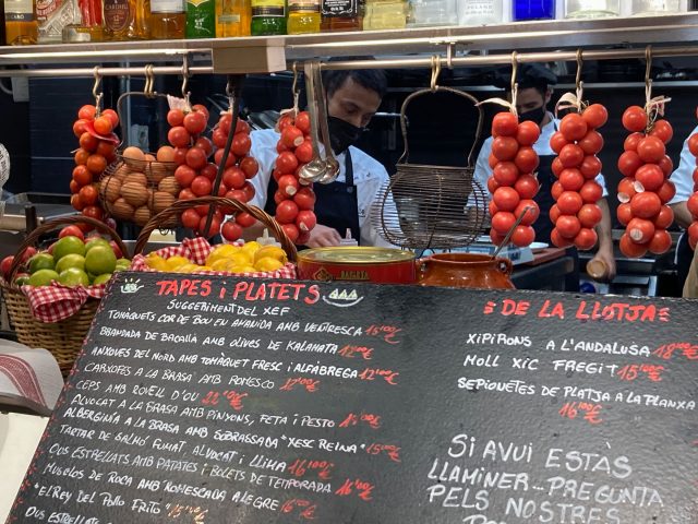 Menu board and ropes of tomatoes in a tapas bar