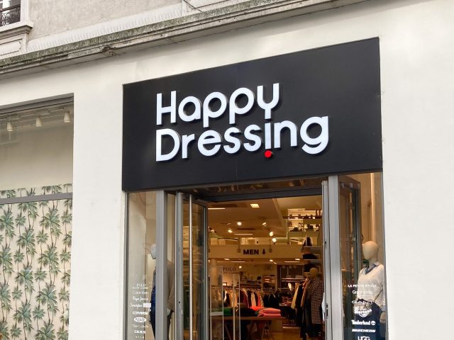 Sign on the front of a clothing store called Happy Dressing
